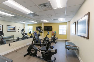 Fitness room with exercise equipment and mirrors