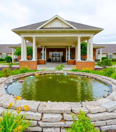 Exterior view of facility entrance with pond and garden