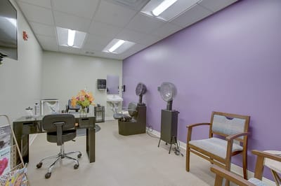 Hair salon with styling chairs and a light purple wall