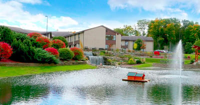 Scenic view of the facility with a pond and gardens