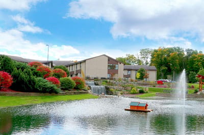 Exterior view of Hubbard Hill Estates with landscaping and water feature