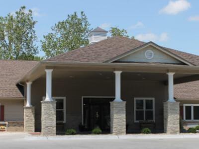 View of the facility's front entrance with a roof and columns.