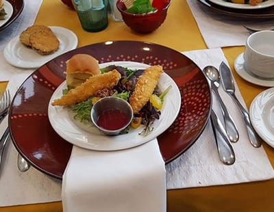 A plated meal with salad, bread, and fish