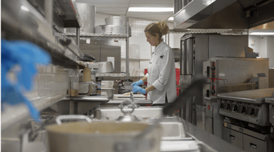 A chef preparing food in the kitchen area