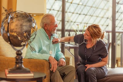 A caregiver attending to an elderly resident indoors