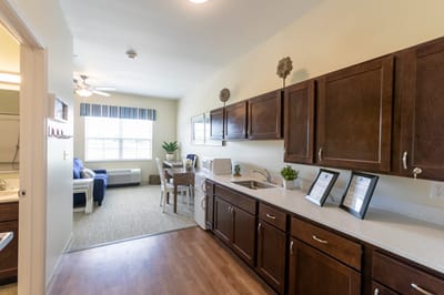 A well-furnished resident room with kitchenette and sitting area
