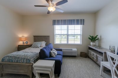 Well-furnished resident room with a bed and seating area