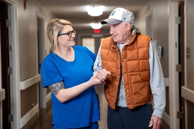 Staff assisting a resident in a hallway