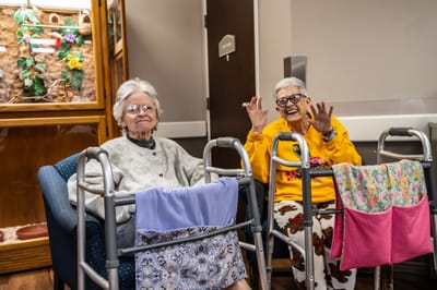 Two residents smiling and sitting in a common room
