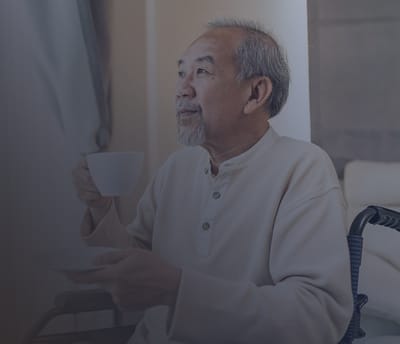 Elderly man enjoying tea in a wheelchair
