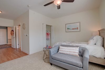 A well-furnished resident room with bed and seating area