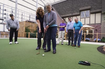 Residents participating in an indoor putting activity