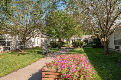 Pathway with benches and flower beds in a senior living garden