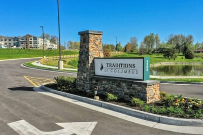 Entrance sign for Traditions of Columbus amidst landscaped area