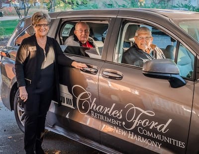Staff member with residents in a facility vehicle