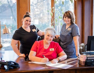 Three staff members at a reception desk