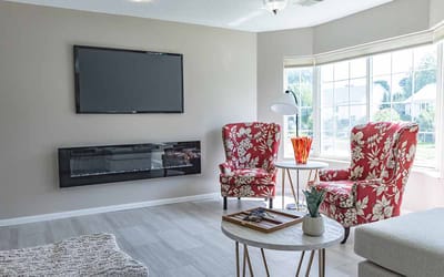 Cozy common area with two red chairs and a TV