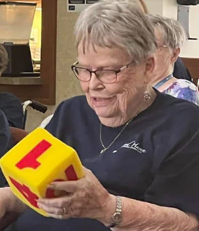 Resident engaged in play with a large toy block