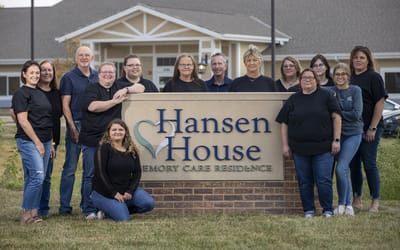 Staff members posing with the facility sign