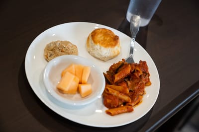 A plate of pasta with biscuits and melon