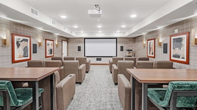 Interior view of a common area with seating and a screen