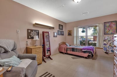 A cozy resident room with a bed and seating area