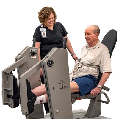Therapist assisting a resident with exercise equipment