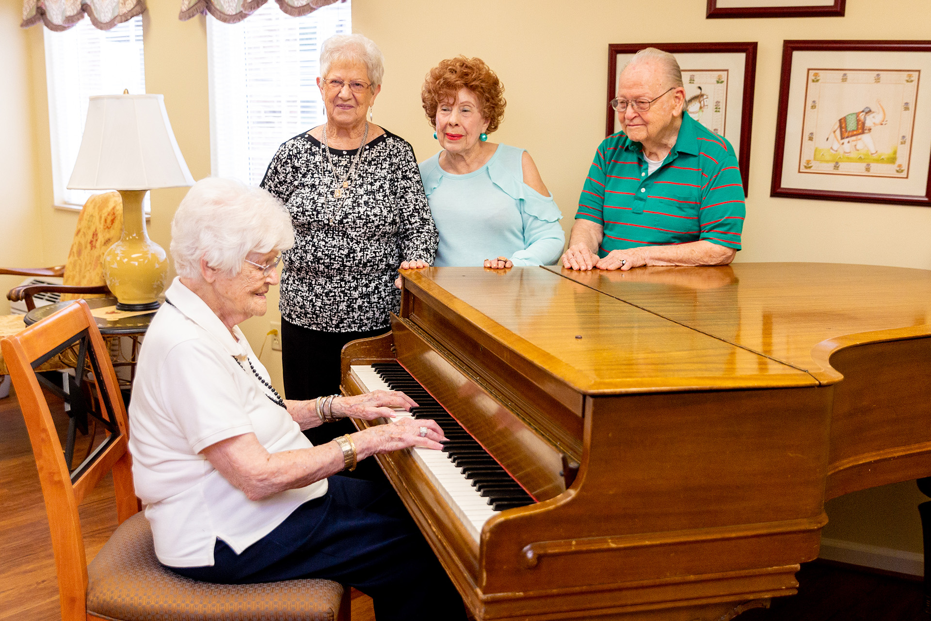 Residents gathered around a piano, engaging with music
