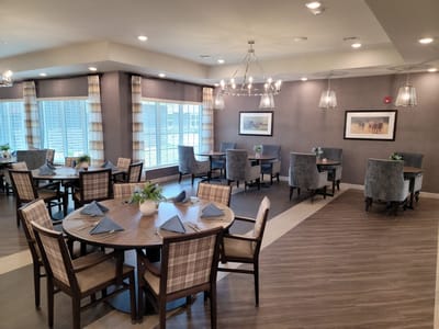 Brightly lit dining room with tables and chairs arranged