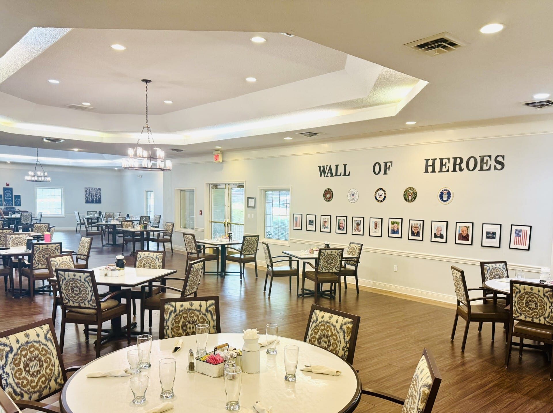 Dining area with 'Wall of Heroes' decor and tables