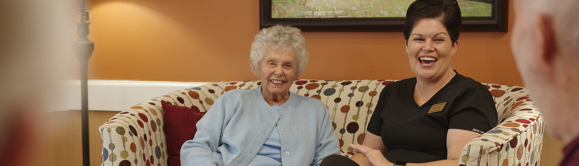 A caregiver and a resident enjoying a conversation in a cozy common area