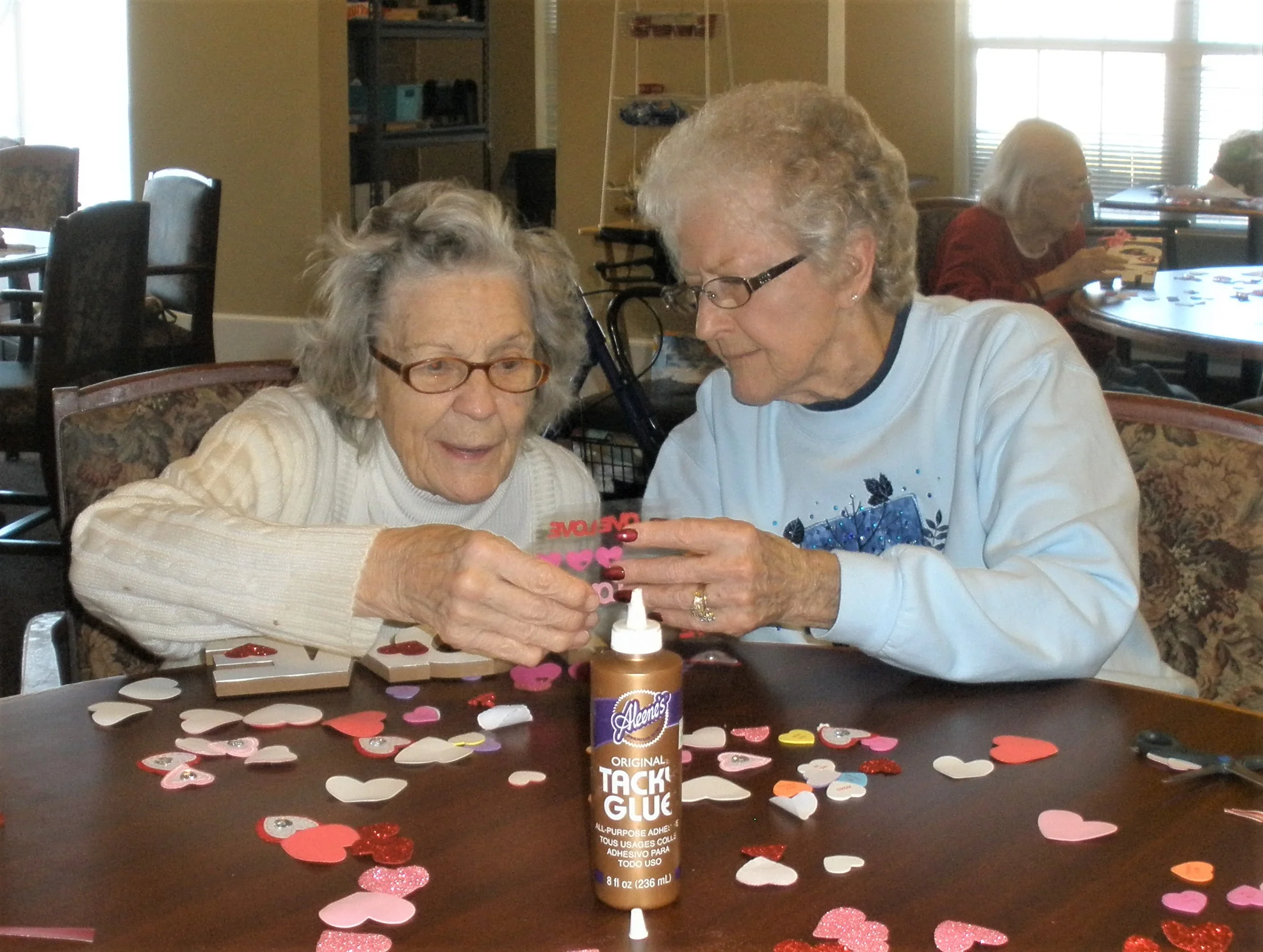 Two residents creating crafts together at a table