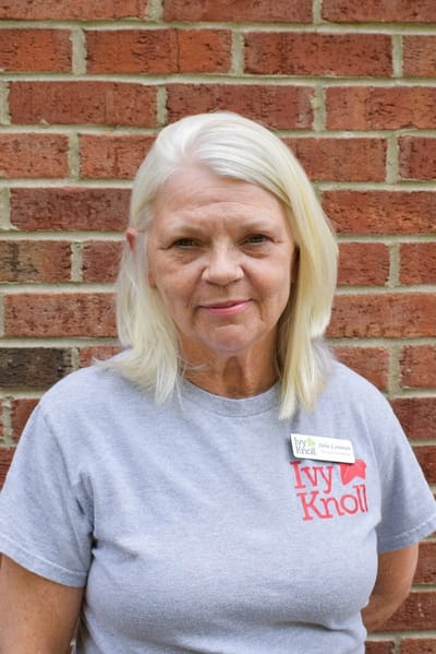 A staff member posing in a gray Ivy Knoll shirt