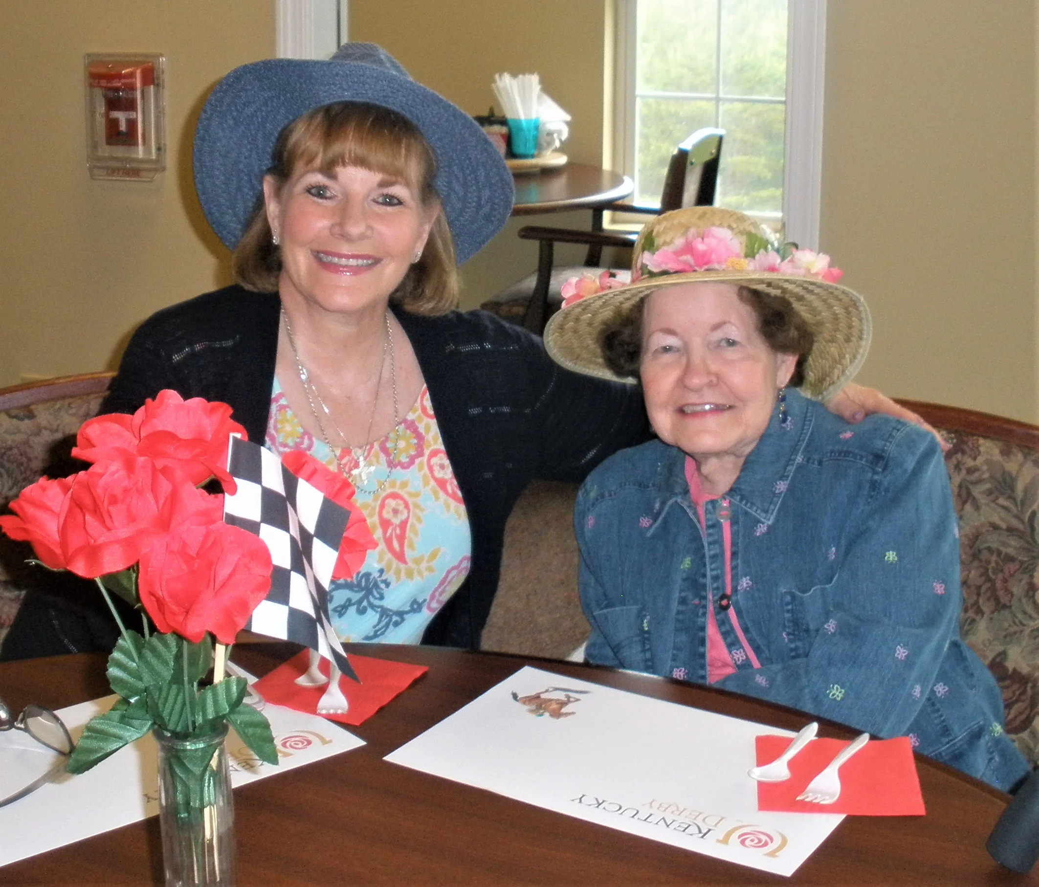 Residents enjoying a gathering with flowers and hats