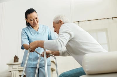 A healthcare worker assisting a senior with mobility