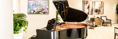 Black grand piano in a bright common area
