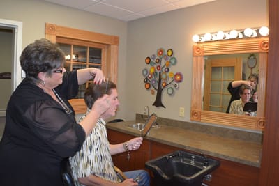 A resident receiving a haircut in the salon