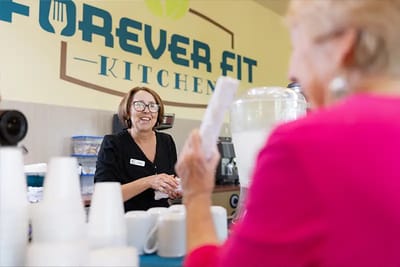 Staff serving residents in a kitchen setting