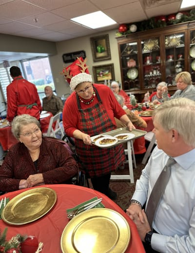 Staff serving food to residents during a festive meal
