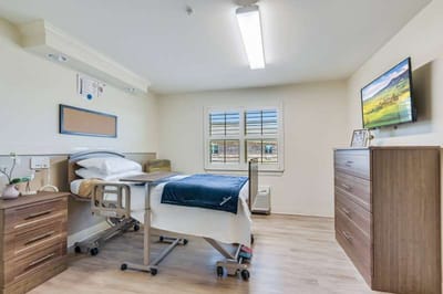 A private resident room with a hospital bed and furniture