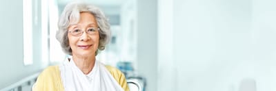 A senior woman smiling in a bright hallway