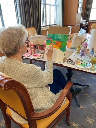 Resident painting in an activity room