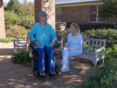 Resident and staff member sitting in garden area