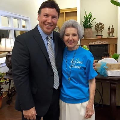 Resident and staff member smiling together in common area