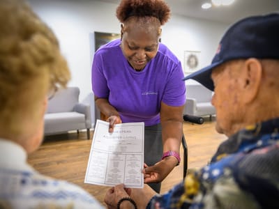 Staff member showing a menu to residents