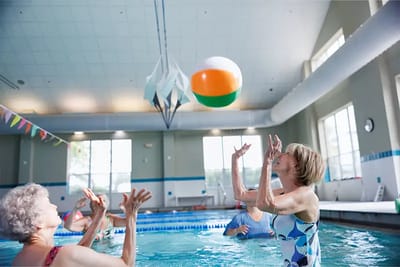 Residents playing water volleyball in the pool