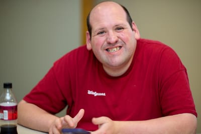 Smiling man at a table with a drink
