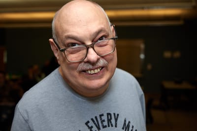 A smiling resident posing for a photo in an indoor setting