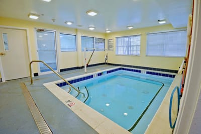 Indoor therapeutic pool area with steps and railing