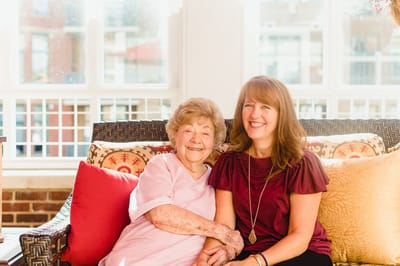 A joyful resident and staff member smiling together